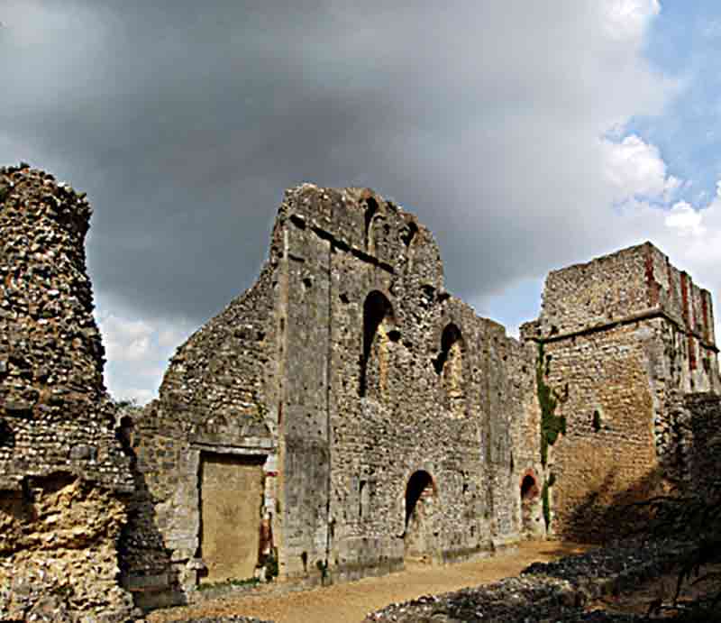 The ruins in sunlight with looming black cloud.