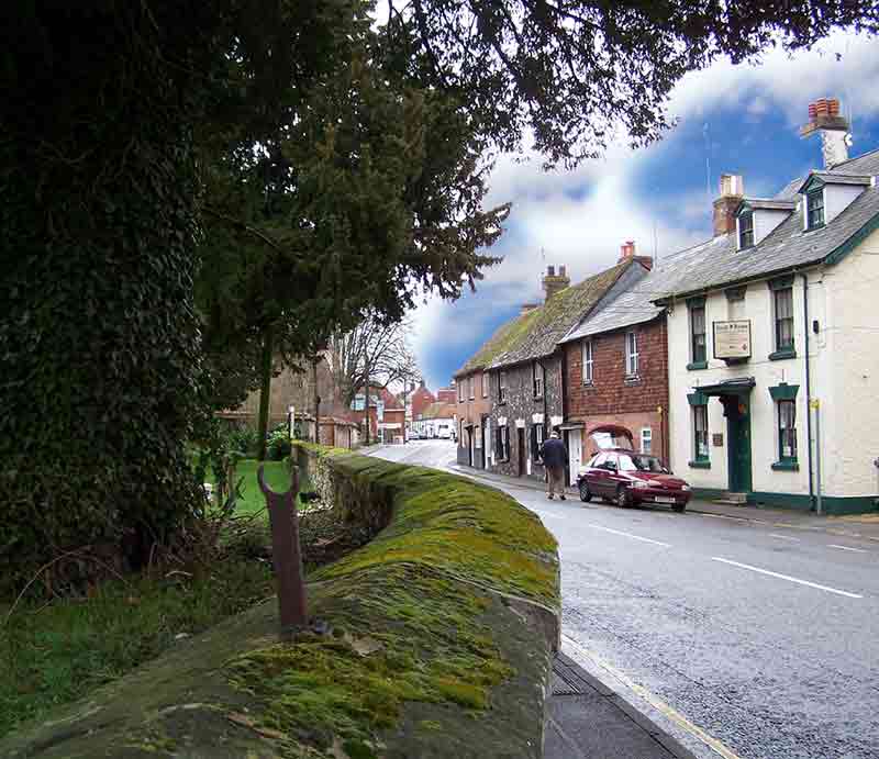 Cottages in a lane with old moss covered wall.